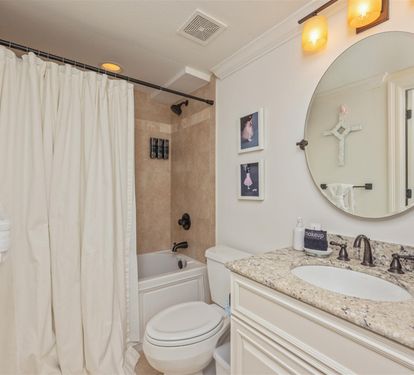 Your elegant bathroom features a relaxing bathtub, granite countertops, and warm lighting for your perfect evening unwind.