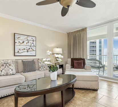 Relax in your sophisticated coastal living room with plush seating and stunning ocean views through floor-to-ceiling windows.