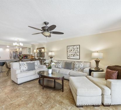 Relax in your spacious living room with plush sectional seating and elegant decor that flows seamlessly into the fully equipped kitchen.