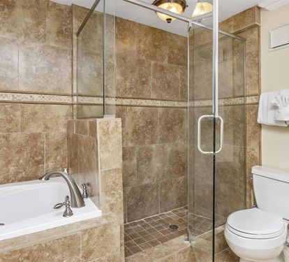 Unwind in your luxurious marble bathroom with a deep soaking tub and spacious glass shower after exploring the day.