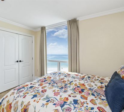 Wake up to stunning ocean views from your coastal bedroom, where vibrant florals and woven textures create a cheerful seaside retreat.