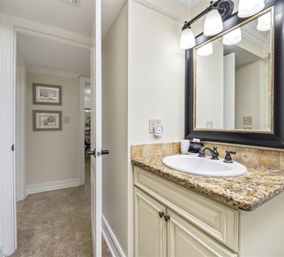 Your private bathroom features elegant granite countertops, classic vanity lighting, and quality fixtures for a comfortable, spa-like experience.