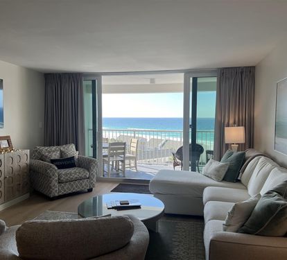Sink into your comfortable living room where stunning ocean views await through floor-to-ceiling windows, creating the perfect backdrop for relaxation.