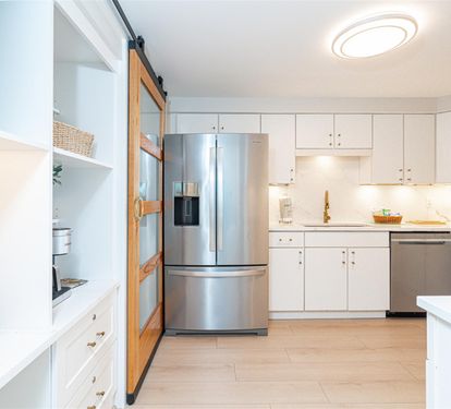 Your spacious kitchen awaits with sleek stainless appliances, pristine white countertops, and thoughtful storage - perfect for cooking memorable meals during your stay.