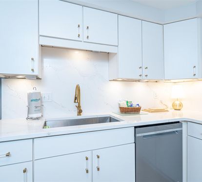 Your bright, modern kitchen features pristine white cabinetry, sleek countertops, and warm under-cabinet lighting for comfortable meal prep.