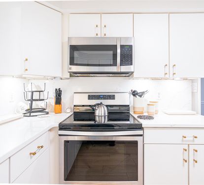 Your bright, fully-equipped kitchen awaits with sleek white cabinetry and modern appliances for effortless meal preparation.