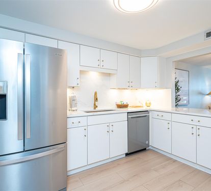 Step into your pristine modern kitchen featuring sleek white cabinetry, stainless steel appliances, and elegant countertops perfect for culinary adventures.
