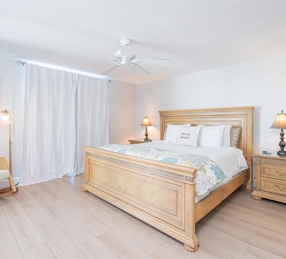 Drift off to peaceful sleep in your beautifully appointed bedroom, where warm wood furnishings and soft coastal colors create the perfect sanctuary for rest.