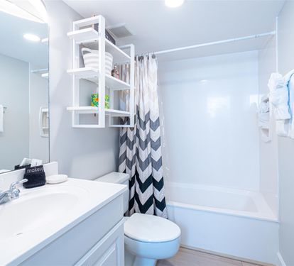 Refresh in your bright, modern bathroom with thoughtful touches like fluffy towels, clever storage, and a spacious shower-tub combo.