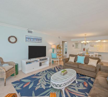 Relax in your bright, coastal-inspired living space with comfortable seating, modern amenities, and an open kitchen perfect for vacation memories.