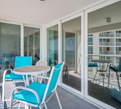 Step onto your private balcony with turquoise seating and enjoy morning coffee while taking in views of neighboring buildings.