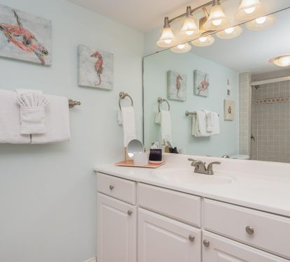 Refresh in your spacious bathroom with coastal charm, featuring soft linens and thoughtful amenities for your perfect getaway.