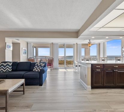 Your open-concept living space flows seamlessly from kitchen to balcony, where stunning ocean views await just beyond the glass doors.