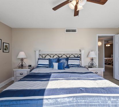 Rest peacefully in this calming bedroom with elegant coastal blues and gentle ceiling fan breezes keeping you comfortable all night.