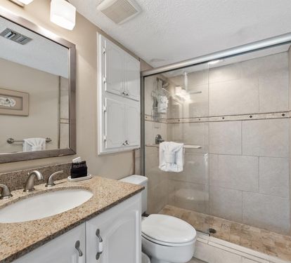 Relax in your private bathroom featuring granite counters, spacious shower, and crisp white towels waiting for you.
