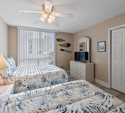 Drift off beneath your ceiling fan while tropical-patterned bedding and warm bedside lighting create coastal comfort in your peaceful retreat.