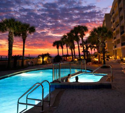 Twilight at the beachfront pool—where sunset skies meet warm water, palm-lined views, and evenings that feel like vacation should.