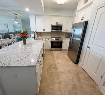 Spacious kitchen with granite countertops, stainless appliances, and bar seating—perfect for coffee mornings or family meals together.