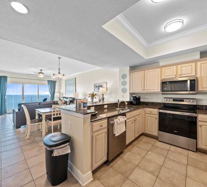Your fully equipped kitchen opens to stunning ocean views, perfect for preparing meals while enjoying the endless blue horizon through floor-to-ceiling windows.