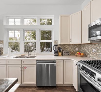 Prep with a view: bright windows, gas cooktop and oven, and stainless steel appliances