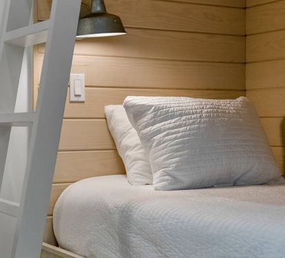 Cozy second-floor bunk nook with reading lights and a shiplap backdrop