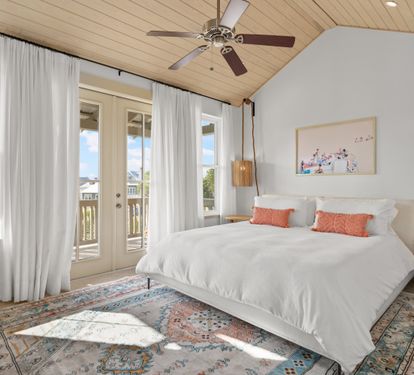 Sunny king bedroom with vaulted ceiling and private balcony access