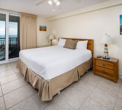 Master Bedroom with King Bed and Floor to Ceiling Sliding Glass Door to Balcony