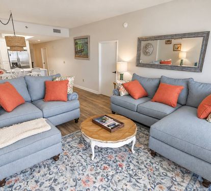 Updated living-room seating with an open dining area and kitchen beyond.