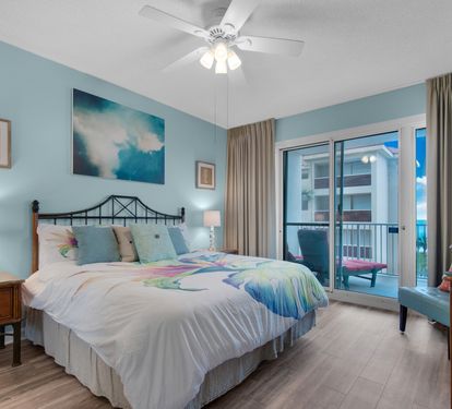 Primary king bedroom with a TV and private balcony access.