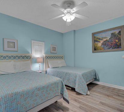 Second bedroom with two full beds and a TV.