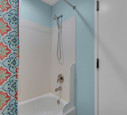 Front bathroom tub and shower; this bathroom is scheduled for an update in late 2026.