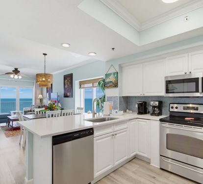 Open kitchen with stainless-steel appliances and Gulf views beyond.