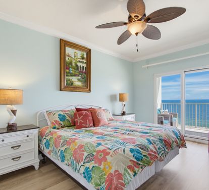 Primary king bedroom with private balcony access, Gulf views, and a TV.