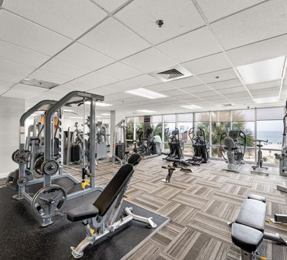 Fitness room with cardio and strength equipment overlooking the Gulf.